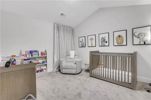 bedroom with lofted ceiling, a crib, carpet flooring, and visible vents