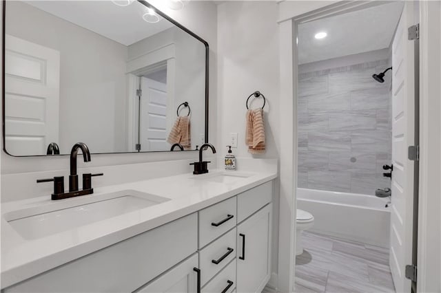 bathroom featuring shower / bath combination, a sink, toilet, and double vanity