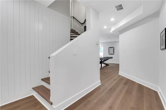 stairs featuring recessed lighting, visible vents, wood walls, wood finished floors, and baseboards