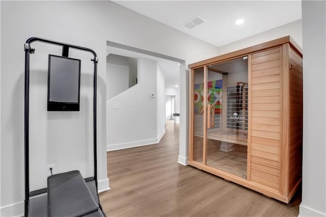 corridor featuring recessed lighting, wood finished floors, visible vents, baseboards, and a sauna