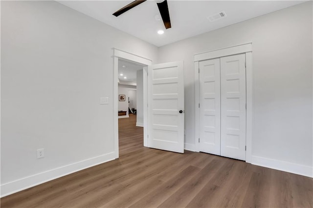 unfurnished bedroom with recessed lighting, visible vents, baseboards, and wood finished floors