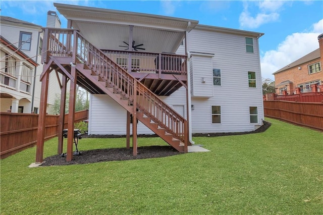 rear view of property with a lawn, stairway, ceiling fan, a deck, and fence