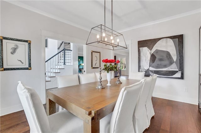 dining room featuring dark wood-style floors, crown molding, baseboards, and stairs