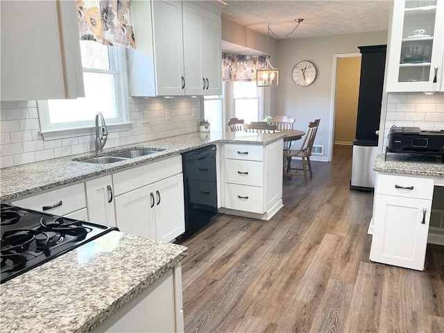 kitchen featuring sink, dishwasher, hanging light fixtures, white cabinets, and decorative backsplash