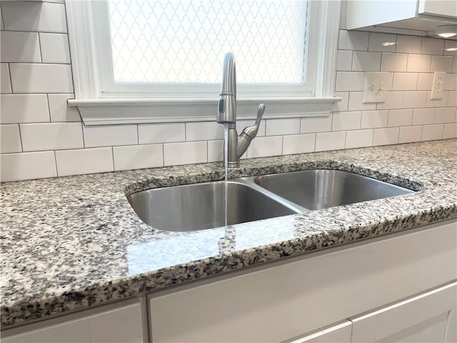 details featuring sink, backsplash, and stone countertops