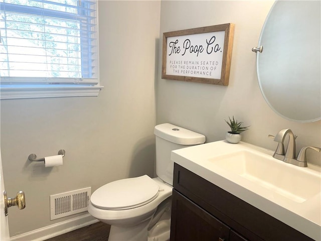 bathroom with hardwood / wood-style flooring, vanity, and toilet