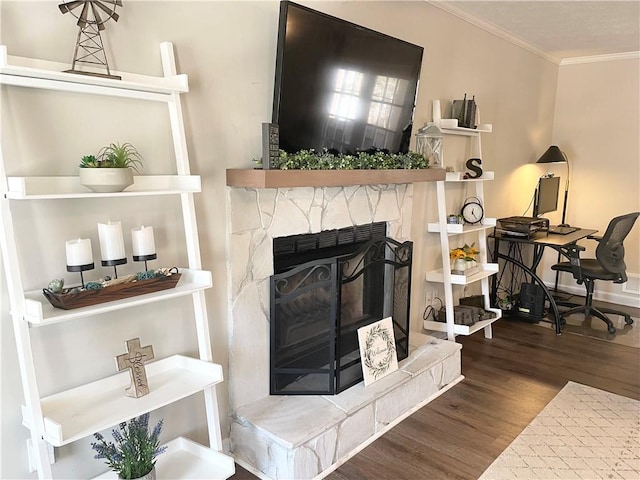 living room with ornamental molding, a stone fireplace, and dark hardwood / wood-style floors