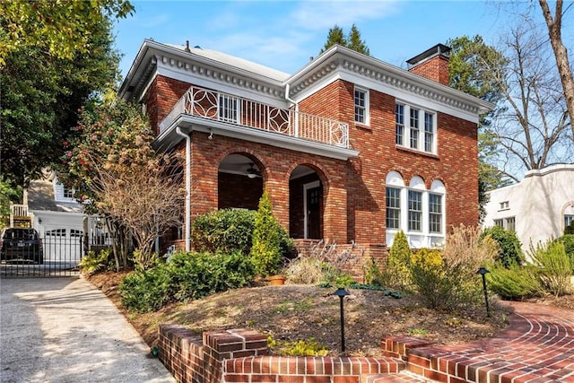 view of front facade with brick siding, a chimney, a porch, and a balcony