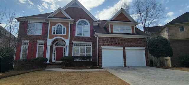 view of front of home with a front yard, a garage, brick siding, and driveway
