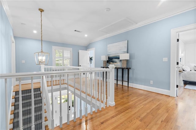 corridor with visible vents, an upstairs landing, vaulted ceiling, baseboards, and light wood-type flooring