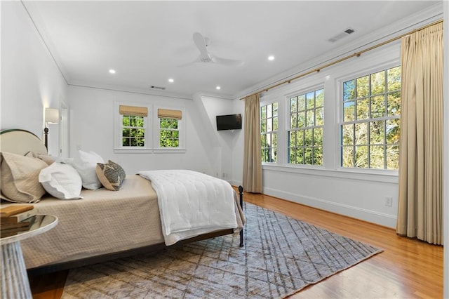 bedroom with recessed lighting, wood finished floors, visible vents, baseboards, and crown molding