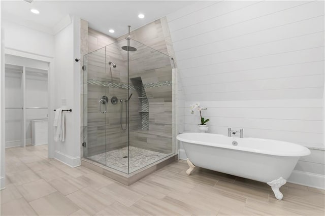 full bathroom with recessed lighting, a stall shower, a soaking tub, and baseboards