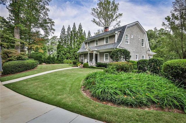 view of front of property featuring a front lawn and a gambrel roof