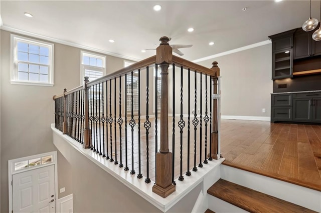 staircase featuring baseboards, ornamental molding, wood finished floors, and recessed lighting