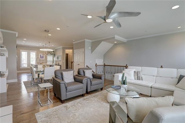 living area featuring crown molding, recessed lighting, a ceiling fan, wood finished floors, and baseboards