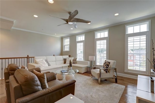 living area with recessed lighting, ornamental molding, ceiling fan, wood finished floors, and baseboards