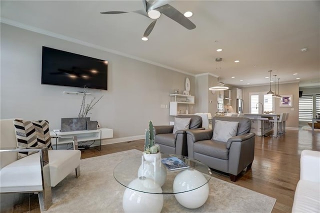 living room with ornamental molding, recessed lighting, wood finished floors, and baseboards