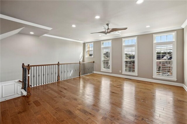 empty room with hardwood / wood-style flooring, a ceiling fan, crown molding, and recessed lighting