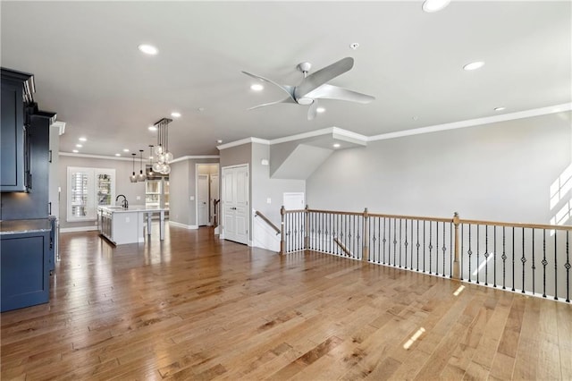 interior space with a ceiling fan, recessed lighting, crown molding, and light wood finished floors