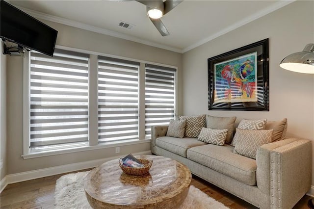 living room featuring baseboards, visible vents, wood finished floors, and ornamental molding