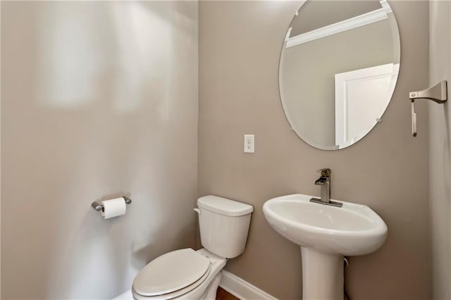 bathroom featuring a sink, toilet, and baseboards