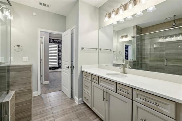 full bath with a shower stall, visible vents, baseboards, and vanity