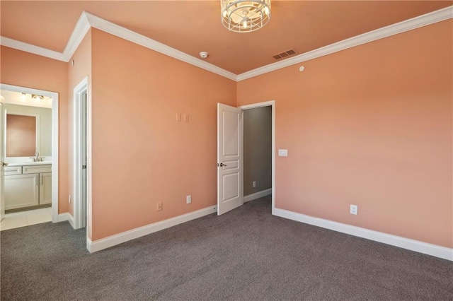 empty room featuring carpet floors, visible vents, ornamental molding, and baseboards