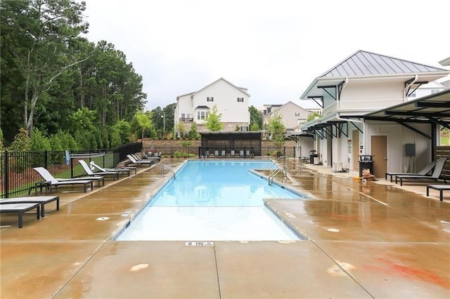 community pool with a patio and fence