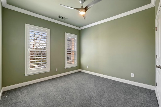 empty room with baseboards, visible vents, a ceiling fan, ornamental molding, and dark colored carpet