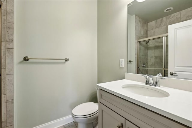 bathroom featuring a stall shower, vanity, toilet, and baseboards