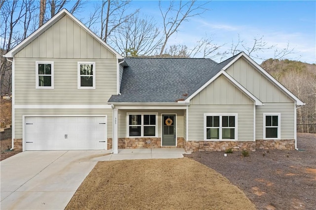 craftsman-style home with board and batten siding, a shingled roof, concrete driveway, stone siding, and an attached garage