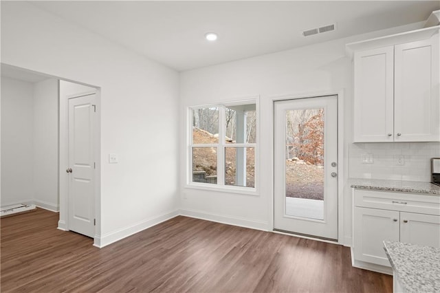 interior space featuring recessed lighting, dark wood-style floors, visible vents, and baseboards