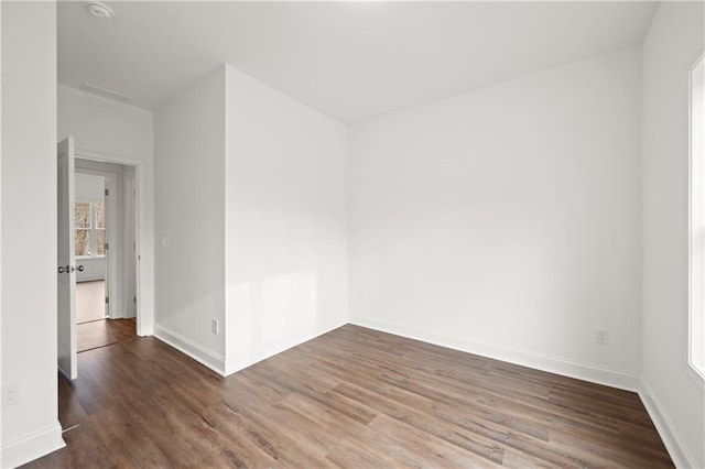 spare room featuring wood finished floors and baseboards