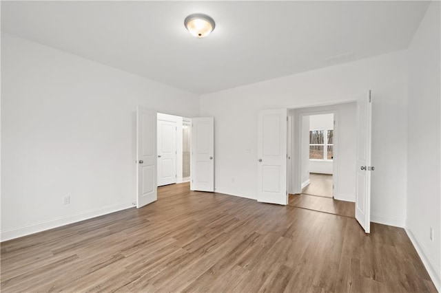 unfurnished bedroom with wood finished floors and baseboards