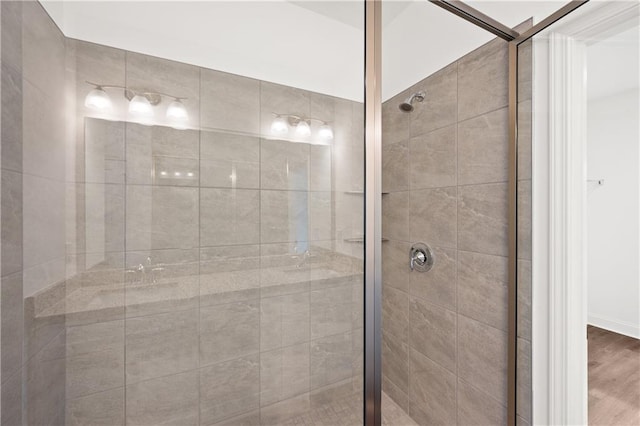 full bath with a shower stall and wood finished floors