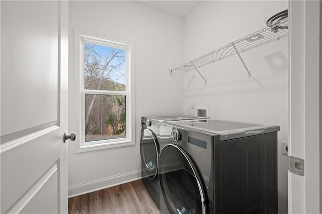 laundry room featuring plenty of natural light, separate washer and dryer, laundry area, and dark wood-type flooring