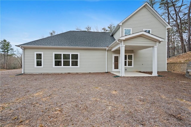 back of property with a patio and a shingled roof