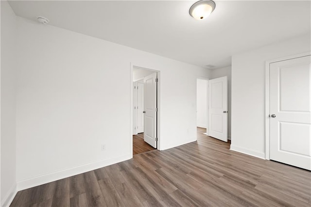 unfurnished bedroom with wood finished floors and baseboards