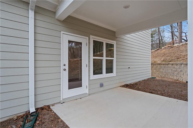 view of exterior entry with a patio