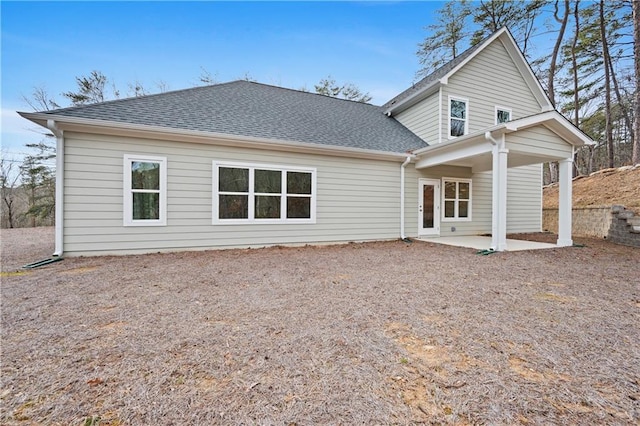 rear view of house with a patio area and a shingled roof