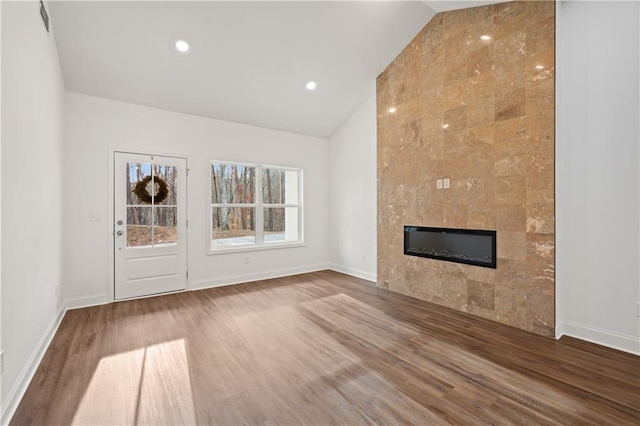 unfurnished living room with wood finished floors, a fireplace, and baseboards