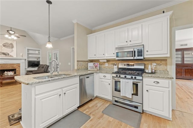 kitchen with appliances with stainless steel finishes, tasteful backsplash, sink, white cabinets, and kitchen peninsula