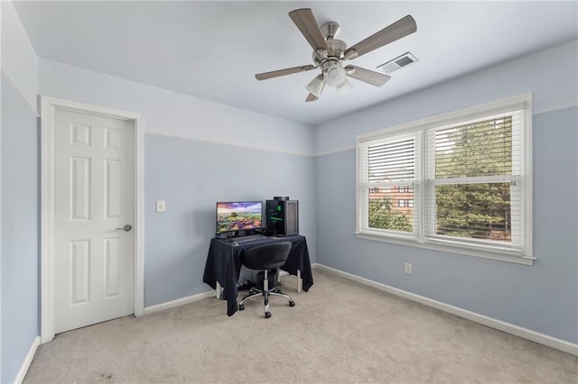 carpeted office space with ceiling fan and a healthy amount of sunlight