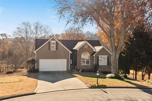 view of property featuring a garage and a front lawn