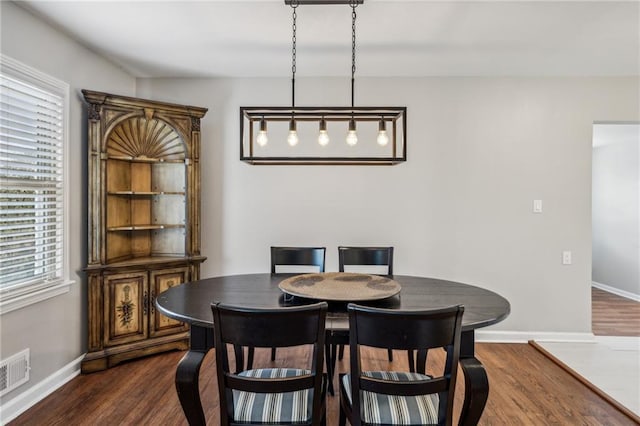 dining area with dark wood-type flooring and a healthy amount of sunlight