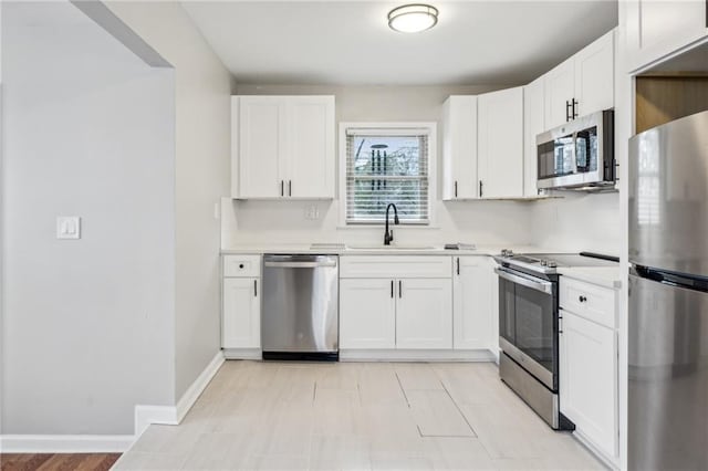 kitchen with white cabinetry, appliances with stainless steel finishes, and sink