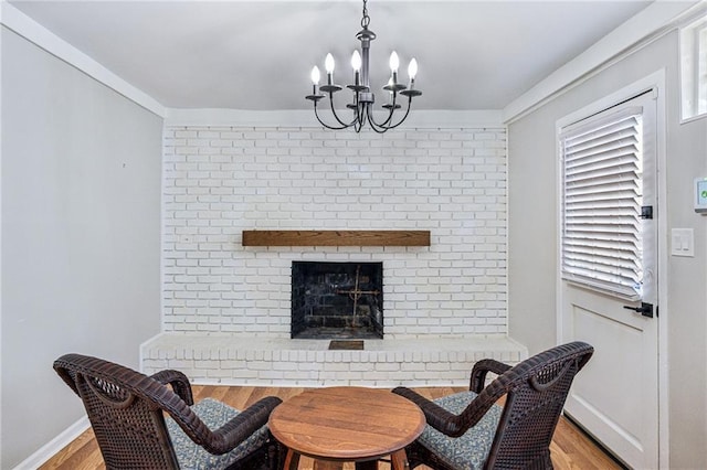 dining room featuring an inviting chandelier, a fireplace, and light hardwood / wood-style floors