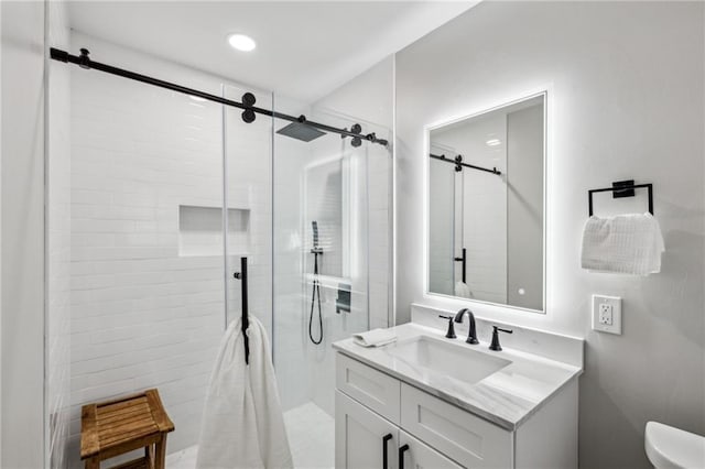 bathroom with an enclosed shower, vanity, and toilet