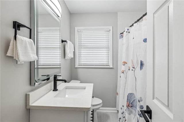 bathroom with vanity, a shower with shower curtain, and toilet