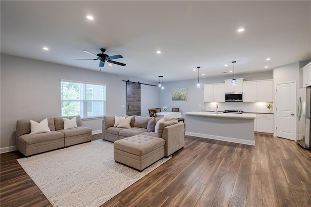 5440 Wheeler Ridge Rd, Auburn, GA 30011 - living area with a barn door, recessed lighting, healthy amount of natural light, dark wood-style flooring, and baseboards